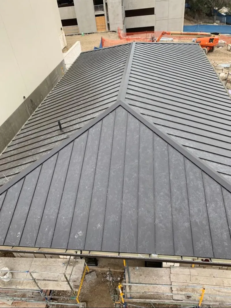 Commercial metal roof construction with crane equipment in Fairfax
